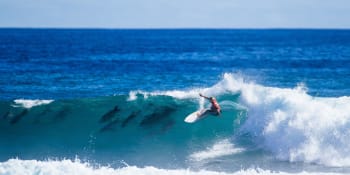 Magické fotky surfařky během boje o titul. Vlnu po jejím boku sjíždělo hejno delfínů